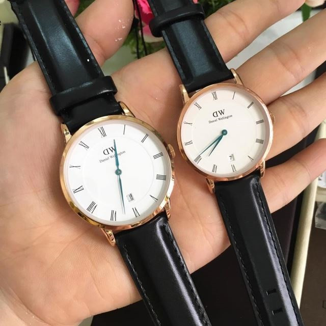 Mẫu đồng hồ DW cao cấp nam dây đen viền vàng hồng trên tay.