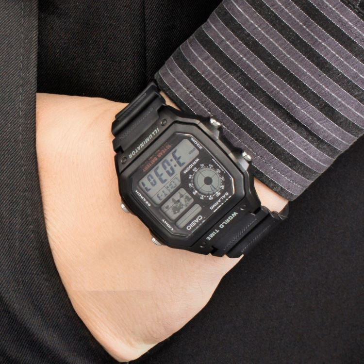 đồng hồ Casio AE-1200WH-1AVDF đeo trên cổ tay với thiết kế mặt vuông và dây nhựa, chuẩn bị cho việc tìm hiểu cách chỉnh giờ đồng hồ Casio AE-1200WH