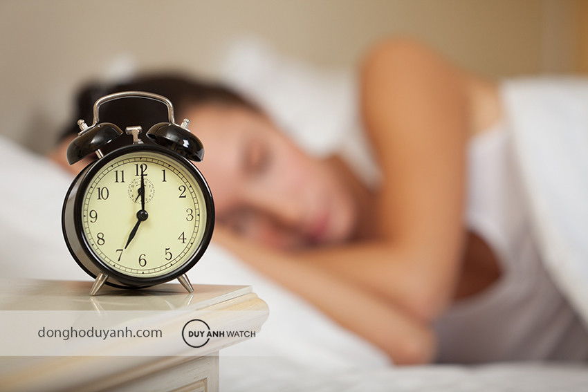 Một chiếc đồng hồ báo thức cổ điển đặt trên tủ đầu giường