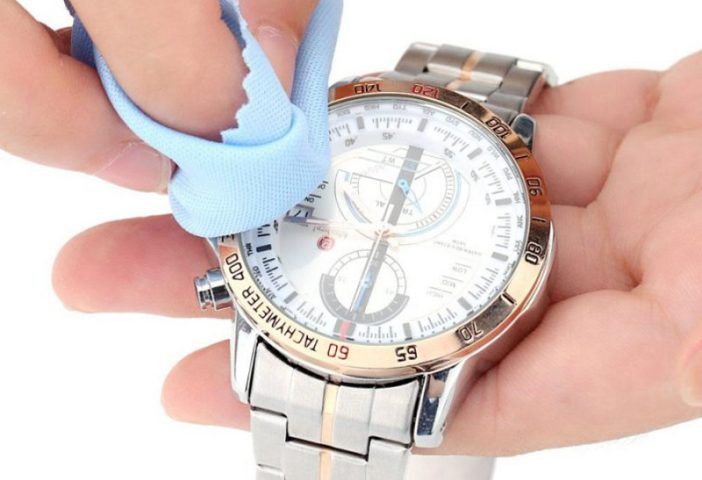 Người dùng đang làm sạch mặt số đồng hồ bằng khăn mềm, minh họa lợi ích của việc vệ sinh đồng hồ định kỳ