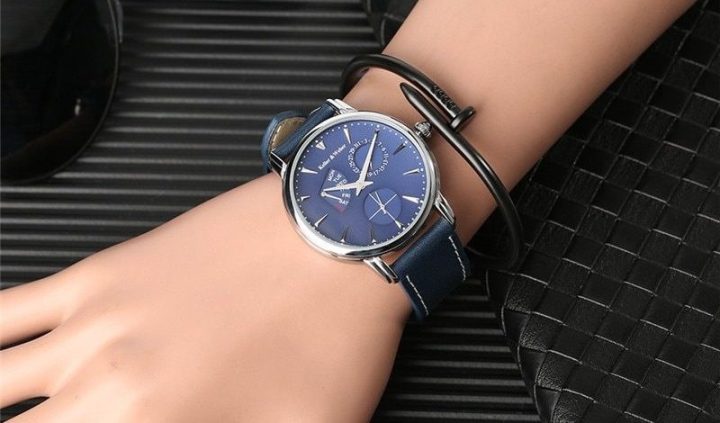 Đồng hồ mặt tròn và dây đeo kim loại trên cổ tay, minh họa việc lựa chọn đồng hồ phù hợp