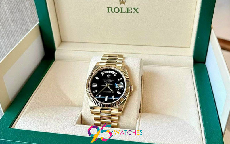 Một chiếc đồng hồ Rolex Daydate Replica 1:1 vỏ vàng 18K và mặt số đen, mang vẻ đẹp sang trọng với giá 10 triệu