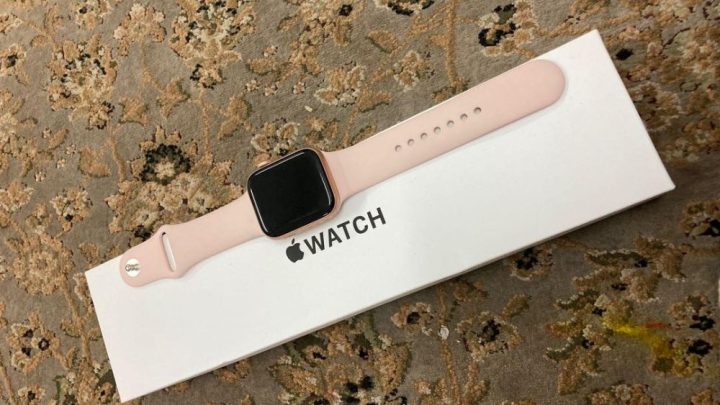Apple Watch màu hồng dây thể thao trên cổ tay nữ, phù hợp với phong cách năng động