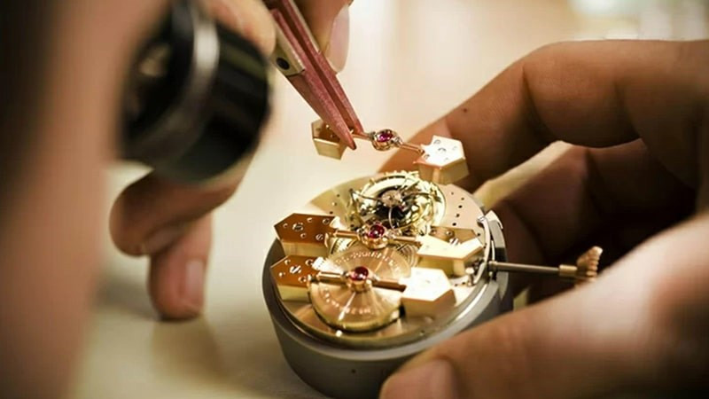 Người thợ đồng hồ đang bảo dưỡng một chiếc đồng hồ, nhấn mạnh tầm quan trọng của việc lau dầu và bảo dưỡng định kỳ để duy trì cách đeo đồng hồ Hublot nữ bền đẹp