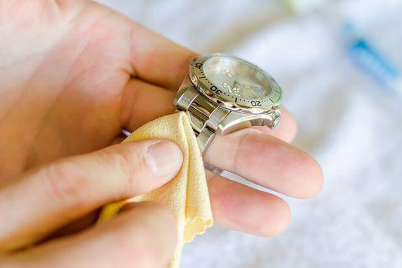 Hình ảnh một người đang lau chùi dây đeo đồng hồ Hublot nữ, minh họa cách vệ sinh đồng hồ Hublot nữ đúng cách để duy trì cách đeo đồng hồ Hublot nữ luôn mới