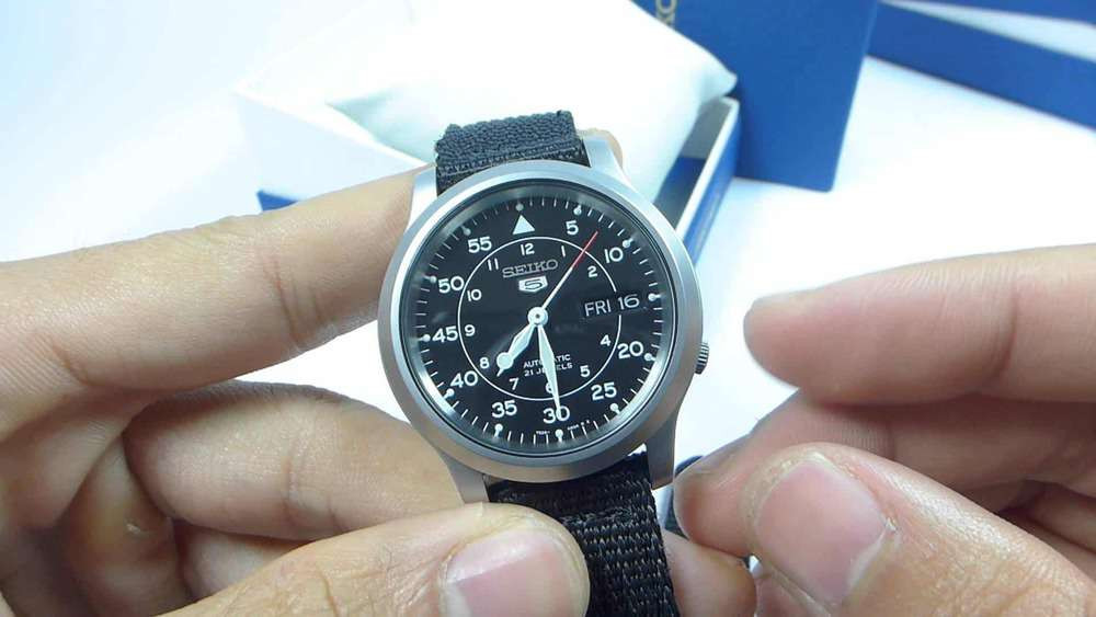 Người dùng thử chức năng lên cót tay trên núm vặn đồng hồ Seiko 5 quân đội để phát hiện đồng hồ Seiko quân đội fake