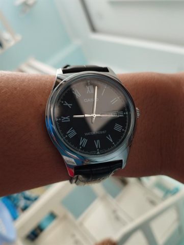 Cận cảnh chiếc đồng hồ Casio MTP-V006L-1BUDF với thiết kế mặt số đen và dây da thanh lịch trên tay người dùng.