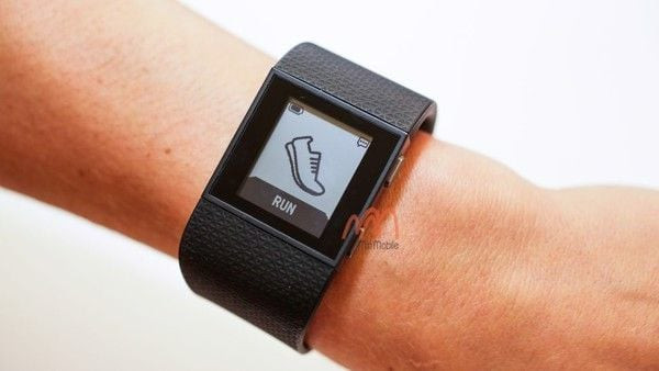 Đồng hồ Fitbit Surge trên cổ tay, thể hiện các cài đặt thông báo để tiết kiệm pin đồng hồ