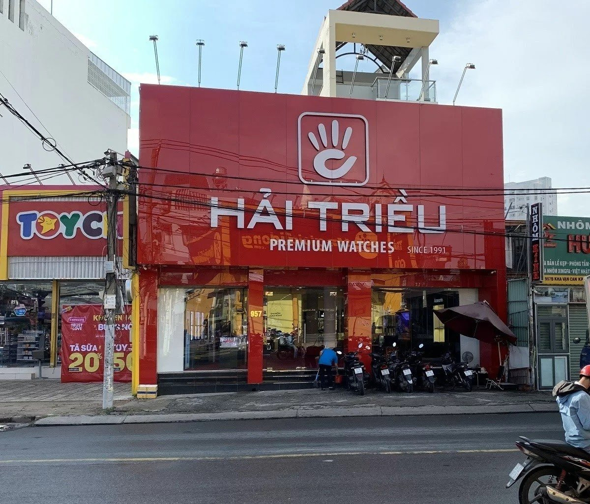 Hình ảnh bên ngoài một cửa hàng sang trọng của Công ty Đồng Hồ Hải Triều, thể hiện chuỗi bán lẻ đồng hồ uy tín.