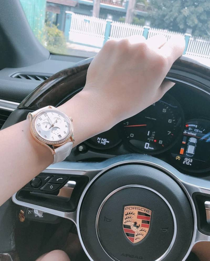 Ảnh chụp đồng hồ đeo tay trên cổ tay nam giới cùng siêu xe màu đen