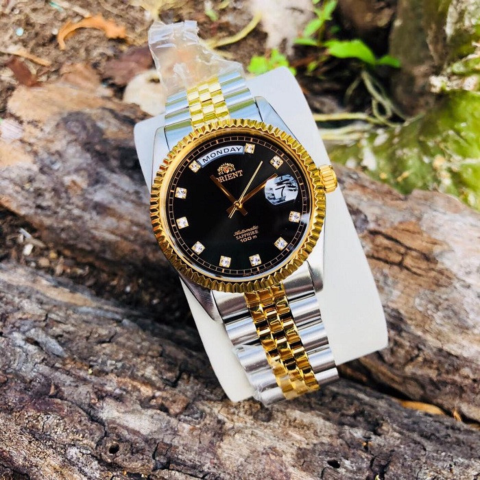 Đồng hồ Orient Oyster EV0J002B với mặt số đen huyền bí và viền khía, tượng trưng cho phong cách Rolex