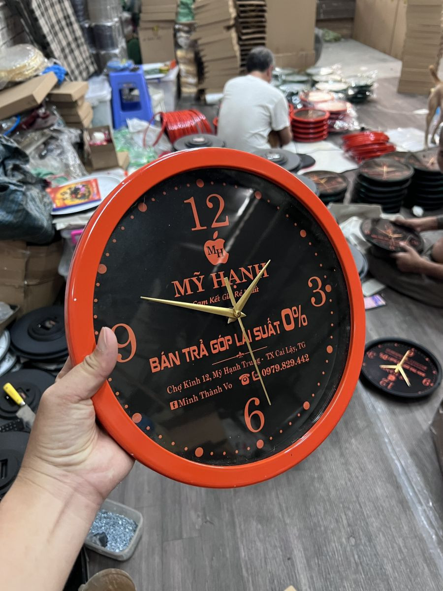 Đồng hồ treo tường in logo của một công ty chuyên về bất động sản, sang trọng và chuyên nghiệp